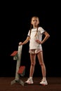Portrait of little girl, beginner athlete in sportswear posing with starting blocks isolated over dark background, Sport Royalty Free Stock Photo