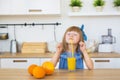 Portrait of a little girl in a blue dress funny eats a spaghetti