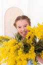 Portrait of a little girl with a bouquet of spring yellow flowers Royalty Free Stock Photo