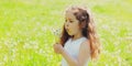 Portrait little girl child blowing dandelions flowers in spring sunny meadow Royalty Free Stock Photo