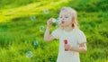 Portrait little girl child blowing soap bubbles in summer park Royalty Free Stock Photo