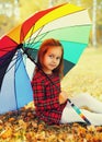 Portrait of little girl child with colorful umbrella in sunny autumn park Royalty Free Stock Photo