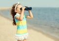 Portrait little girl child looking through binoculars on a sea beach Royalty Free Stock Photo