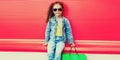 Portrait of little girl child with shopping bags wearing denim clothes on the city street Royalty Free Stock Photo