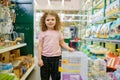 Portrait of little girl child standing nearby cage for rodent at pet shop Royalty Free Stock Photo