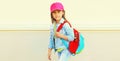 Portrait of little girl child wearing baseball cap with backpack on city street Royalty Free Stock Photo