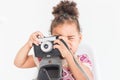 Portrait of a little girl in a colorful dress taking pictures on an old vintage camera Royalty Free Stock Photo