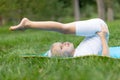 Portrait of little  girl doing yoga in in green grass.Child doing exercise on platform outdoors. Royalty Free Stock Photo