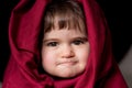 Portrait of a little girl dressed as red riding hood, with a quirky look and biting the lip Royalty Free Stock Photo