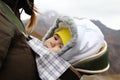 Portrait of little girl in ergo carrier with her mother on a background of autumn mountains Royalty Free Stock Photo