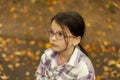 Portrait of a little girl with eyeglasses in autumn park Royalty Free Stock Photo