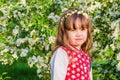 Portrait of a little girl in a flourishing Apple orchard