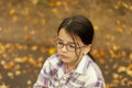 Portrait of a little girl with glasses in the autumn park Royalty Free Stock Photo