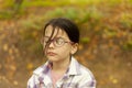 Portrait of a little girl with glasses in the autumn park Royalty Free Stock Photo