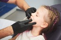 Portrait of little girl has a dental examination while sitting at dentist office. Male dentist is checking the young Royalty Free Stock Photo