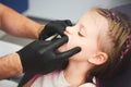 Portrait of little girl has a dental examination while sitting at dentist office. Male dentist is checking the young Royalty Free Stock Photo