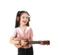 Portrait of little girl with headphones playing guitar Royalty Free Stock Photo