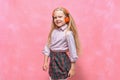 Portrait of little girl in headphones. schoolgirl in uniform. pink background