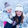 Portrait of a little girl and her mother in winter hat in snow f Royalty Free Stock Photo