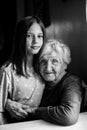 Portrait of little girl and her old great-grandmother. Black and white photo. Royalty Free Stock Photo