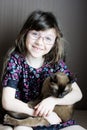 Portrait of little girl holding burmese cat