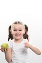 Portrait of a little girl holding a green apple in her hand and showing the class with her other hand Royalty Free Stock Photo