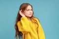 Portrait of little girl holding hand near ear and listening carefully intently to what you say.