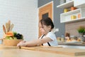 Portrait of a little girl in the kitchen of a house having fun playing with fruit toy Royalty Free Stock Photo