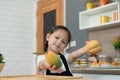 Portrait of a little girl in the kitchen of a house having fun playing with fruit toy Royalty Free Stock Photo