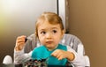 Portrait of a little girl in the kitchen with a plate of muesli and berries. The concept of instilling a healthy diet