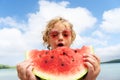 Portrait little girl licking fresh watermelon slice posing on beach having fun and positive emotion Royalty Free Stock Photo