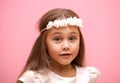 Portrait of a little girl with long hair on a pink background