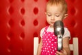 Portrait of little girl with microphone on rack Royalty Free Stock Photo