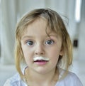 Portrait of a little girl with milk moustaches.