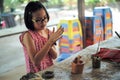 Portrait little girl molds the clay for producing the pottery work in workshop class