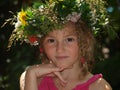 Portrait of a little girl with pigtails and a bright wreath of fresh flowers on her head Royalty Free Stock Photo