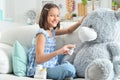 Little girl playing doctor with toy bear in facial mask Royalty Free Stock Photo