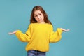 Portrait of little girl raising hands in questioning gesture, unsure of answer, expressing doubts.