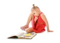 Portrait of a little girl reading books, sitting on the floor