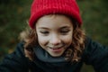 Portrait of little girl in red knitted hat. Red riding hood girl, little redcap lookalike.