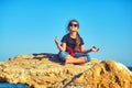 Portrait of a little girl relaxing on the seashore sitting on a rock