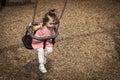 Portrait of a little girl riding on a swing.