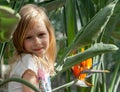 portrait, little girl seven years, sits next strelitzia