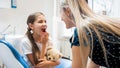 Portrait of little girl showing teeth to her mother after teeth treatment in dentist office Royalty Free Stock Photo