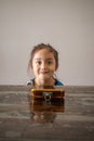 Portrait of a little girl sitting at the table with mobile phone in front of her. watching videos on the handphone Royalty Free Stock Photo