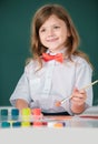 Portrait of little girl smiling happily while enjoying art and craft drawing lesson. Child girl drawing with coloring