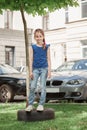 Portrait of a little girl standing in the city yard