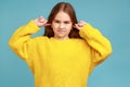 Portrait of little girl standing with closed ears not to hear parental advice, ignoring upbringing. Royalty Free Stock Photo