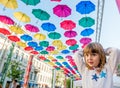 Portrait Little Girl In The Street Decorated With Colored Umbrellas