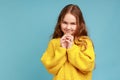 Portrait of little girl thinking over cunful idea and smiling at camera, having tricky plans in mind